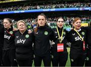 23 September 2023; Republic of Ireland staff, from left, social media coordinator Emma Clinton, operations manager Evelyn McMullan, masseuse Hannah Tobin Jones, physiotherapist Susie Coffey and Dr Siobhan Forman, team doctor; stand for the playing of the National Anthem before the UEFA Women's Nations League B1 match between Republic of Ireland and Northern Ireland at Aviva Stadium in Dublin. Photo by Stephen McCarthy/Sportsfile