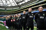 23 September 2023; Republic of Ireland assistant coach Colin Healy, with, from left, goalkeeping coach Richie Fitzgibbon, assistant coach Emma Byrne, STATSports analyst Claire Dunne, performance coach Ivi Casagrande, physiotherapist Angela Kenneally, Dr Siobhan Forman, team doctor; physiotherapist Susie Coffey, masseuse Hannah Tobin Jones, and operations manager Evelyn McMullan stand for the playing of the National Anthem before the UEFA Women's Nations League B1 match between Republic of Ireland and Northern Ireland at Aviva Stadium in Dublin. Photo by Stephen McCarthy/Sportsfile