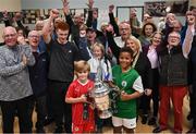28 September 2023; Cliftonville FC player Ollie Thompson, age 7, left, and St Patrick's FC player Leroy Agunbiade, age 11, with locals as descendants of Alton United receive the Sports Direct Men’s FAI Cup for the first time in Carrick Hill, Belfast on the 100th anniversary of the Club winning the Cup as the only Belfast team to win the competition in its history. Photo by David Fitzgerald/Sportsfile