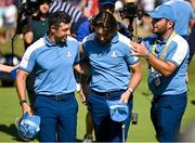 29 September 2023; Rory McIlroy, left, and Tommy Fleetwood of Europe, centre, are congratulated by vice-captain Francesco Molinari after their victory during the morning foursomes matches on day one of the 2023 Ryder Cup at Marco Simone Golf and Country Club in Rome, Italy. Photo by Brendan Moran/Sportsfile