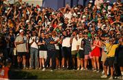 29 September 2023; Brooks Koepka of USA and spectators in the galleries watch the flight of his ball after playing a shot from the rough at the 18th green during the afternoon fourball matches on day one of the 2023 Ryder Cup at Marco Simone Golf and Country Club in Rome, Italy. Photo by Brendan Moran/Sportsfile