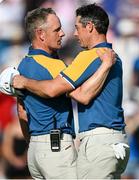 1 October 2023; Rory McIlroy of Europe celebrates with Europe captain Luke Donald on the 17th green after winning his match against Sam Burns of USA  during the singles matches on the final day of the 2023 Ryder Cup at Marco Simone Golf and Country Club in Rome, Italy. Photo by Ramsey Cardy/Sportsfile