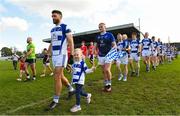 1 October 2023; Saoirse Redmond, age 4, with her dad Tinryland captain Shane Redmond during the parade before the Carlow County Senior Club Football Championship final match between Tinryland and Éire Óg at Netwatch Cullen Park in Carlow. Photo by Matt Browne/Sportsfile