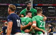 7 October 2023; Hugo Keenan of Ireland, left, celebrates with teammates Caelan Doris, top, and Stuart McCloskey, right, after scoring their side's second try during the 2023 Rugby World Cup Pool B match between Ireland and Scotland at the Stade de France in Paris, France. Photo by Harry Murphy/Sportsfile