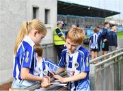 8 October 2023; Ballyboden St Endas supporters Josh Masterson, aged 10, right, and Adeline Smyth, aged 8, study the programme before the Dublin County Senior Club Football Championship semi-final match between St Judes and Ballyboden St Endas at Parnell Park in Dublin. Photo by Sam Barnes/Sportsfile