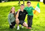 9 October 2023; Rhys McClenaghan of Ireland, centre, pictured with his gold medal and Isabelle, 11, left, with Douglas Ledwith, 5, from Batterstown, Meath, on his return at Dublin Airport after winning in the Men's Pommel Horse Final at the 2023 World Artistic Gymnastics Championships. Photo by Ramsey Cardy/Sportsfile