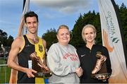15 October 2023; Eoin Everard of Kilkenny City Harriers AC, left, and Noeleen Scanlon of Letterkenny AC, Donegal, right, are presented with the Jim McNamara trophy by Andrea McNamara after winning the master men's 8000m and master women's 6000m respectively, during the Autumn Open International Cross Country Festival & The Athletics Ireland Cross County Xperience at Abbotstown in Dublin. Photo by Sam Barnes/Sportsfile