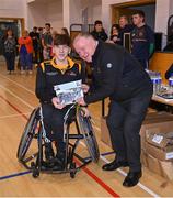 21 October 2023; GAA Carlow county chairperson Jim Bolger presents Ireland player Damhan Hughes of Ulster with a commemorative plaque for their trip to Prague earlier this year before the 2023 Wheelchair Hurling / Camogie All Ireland Finals at SETU Carlow Sports Hall in Carlow. Photo by Ben McShane/Sportsfile