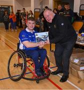 21 October 2023; GAA Carlow county chairperson Jim Bolger presents Ireland player Maurice Noonan of Munster with a commemorative plaque for their trip to Prague earlier this year before the 2023 Wheelchair Hurling / Camogie All Ireland Finals at SETU Carlow Sports Hall in Carlow. Photo by Ben McShane/Sportsfile