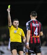27 October 2023; Referee Rob Hennessy issues a yellow card to Krystian Nowak of Bohemians during the SSE Airtricity Men's Premier Division match between Dundalk and Bohemians at Oriel Park in Dundalk, Louth. Photo by Ben McShane/Sportsfile