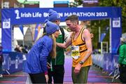 29 October 2023; Ryan Creech from Cork with Lizzie Lee, left, and Race Director Jim Aughney after the 2023 Irish Life Dublin Marathon. Thousands of runners took to the Fitzwilliam Square start line, to participate in the 42nd running of the Dublin Marathon. Photo by Sam Barnes/Sportsfile