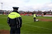 4 November 2023; A member of the Garda Síochána looks on as groundsman Sean Murphy prepares the pitch before the SSE Airtricity Men's First Division Play-Off Final between Waterford and Cobh Ramblers at Turner's Cross in Cork. Photo by Michael P Ryan/Sportsfile
