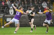 5 November 2023; Miceal Rooney of Kilcoo in action against Leigh Jones, left, and Michael Jones of Derrygonnelly Harps during the AIB Ulster GAA Football Senior Club Championship round 1 match between Derrygonnelly Harps of Fermanagh and Kilcoo of Down at Brewster Park in Enniskillen, Fermanagh. Photo by Ramsey Cardy/Sportsfile