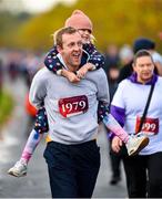 12 November 2023; Denis Kealy, in remembrance of his daughter Hannah, carries his cousin Heidi Lawlor over the finish line during the Remembrance Run 5K, supported by Silver Stream Healthcare, at the Phoenix Park in Dublin. Photo by Brendan Moran/Sportsfile