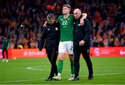 18 November 2023; Nathan Collins of Republic of Ireland is assisted from the pitch by Republic of Ireland team doctor Sean Carmody, left, and Republic of Ireland athletic therapist Colum O’Neill, right, after the UEFA EURO 2024 Championship qualifying group B match between Netherlands and Republic of Ireland at Johan Cruijff ArenA in Amsterdam, Netherlands. Photo by Stephen McCarthy/Sportsfile