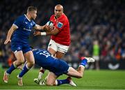 25 November 2023; Simon Zebo of Munster is tackled by Hugo Keenan, bottom, and Jordan Larmour of Leinster during the United Rugby Championship match between Leinster and Munster at the Aviva Stadium in Dublin. Photo by Sam Barnes/Sportsfile