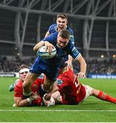 25 November 2023; Jordan Larmour of Leinster scores his side's third try despite Alex Kendellen, left, and Jean Kleyn of Munster during the United Rugby Championship match between Leinster and Munster at the Aviva Stadium in Dublin. Photo by David Fitzgerald/Sportsfile