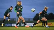 28 November 2023; Izzy Atkinson gets her shot away past Jamie Finn and Jessie Stapleton, right, during a Republic of Ireland women training session at the FAI National Training Centre in Abbotstown, Dublin. Photo by Stephen McCarthy/Sportsfile