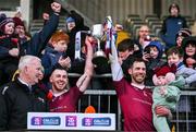 3 December 2023; Ruairí Óg captain Neil McManus, right, with daughter Aoibhinn, age 1, and vice-captain Ryan McCambridge lift the cup after the AIB Ulster GAA Hurling Senior Club Championship final match between Ruairi Óg, Antrim, and Slaughtneil, Derry, at Páirc Esler in Newry, Down. Photo by Ben McShane/Sportsfile