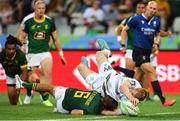 9 December 2023; Gavin Mullin of Ireland dives over Tiaan Pretorius of South Africa to score a try during the Men's Pool A match between South Africa and Ireland during the HSBC SVNS Rugby Tournament at DHL Stadium in Cape Town, South Africa. Photo by Shaun Roy/Sportsfile