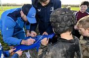 10 December 2023; As part of the club’s 12 County Tour, Leinster Rugby players Jack Conan and Ross Byrne visited Roscrea RFC for their minis’ Christmas Party. Pictured are Jack Conan and Ross Byrne signing the jersey of supporter Lorcan Shannon at Roscrea RFC in Tipperary. Photo by Tyler Miller/Sportsfile