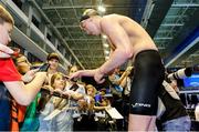 10 December 2023; Daniel Wiffen of Ireland signs autographs for fans after his victory in the Men's 800m Freestyle, setting a new world record of 7:20.46, during day six of the European Short Course Swimming Championships 2023 at the Aquatics Complex in Otopeni, Romania. Photo by Nikola Krstic/Sportsfile