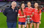16 December 2023; Kilkerrin-Clonberne players, from right, Olivia Divilly, Siobhán Divilly and Niamh Divilly with their dad Michael and the Dolores Tyrrell Memorial Cup after their side's victory in the Currentaccount.ie LGFA All-Ireland Senior Club Championship final match between Ballymacarby of Waterford and Kilkerrin-Clonberne of Galway at Croke Park in Dublin. Photo by Piaras Ó Mídheach/Sportsfile