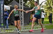 17 December 2023; Kate Veale of Ireland, left, takes over from team-mate Brendan Boyce in the marathon mixed relay during the National Race Walking Championships and World Athletics Race Walking Tour Bronze at Raheny Park in Dublin. Photo by Sam Barnes/Sportsfile