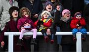 29 December 2023; Racegoers, from left, Paula Woofson with Lara Hernon, aged four, Ruth Woofson with Charlie, aged three, and Pauline Woofson with Cillian, aged two, cheer home runners and riders in the Adare Manor Opportunity Handicap Steeplechase on day four of the Leopardstown Christmas Festival at Leopardstown Racecourse in Dublin. Photo by Harry Murphy/Sportsfile