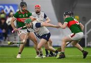 6 January 2024; Aidan Organ of New York evades the tackle of Danny Hill of Mayo, left, and Evan Hearty during the Connacht Hurling League Cup final match between New York and Mayo at University of Galway Connacht GAA AirDome in Bekan, Mayo. Photo by Tyler Miller/Sportsfile
