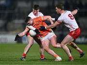 10 January 2024; Tiernan Kelly of Armagh is tackled by Ben Cullen, left, and Brian Kennedy of Tyrone during the Bank of Ireland Dr McKenna Cup Group A match between Armagh and Tyrone at BOX-IT Athletic Grounds in Armagh. Photo by Ben McShane/Sportsfile