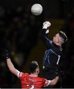 20 January 2024; Donegal goalkeeper Gavin Mulreany fists cear under pressure from Diarmuid Baker of Derry during the Bank of Ireland Dr McKenna Cup final match between Derry and Donegal at O'Neills Healy Park in Omagh, Tyrone. Photo by Ramsey Cardy/Sportsfile