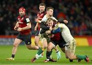 20 January 2024; Craig Casey of Munster is tackled by Rory Hutchinson and Fraser Dingwall of Northampton Saints during the Investec Champions Cup Pool 3 Round 4 match between Munster and Northampton Saints at Thomond Park in Limerick. Photo by Brendan Moran/Sportsfile
