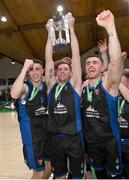 20 January 2024; UCC Demons captain Kyle Hosford, with teammates James Hannigan, left, and Scott Hannigan, celebrate with the trophy after their side's victory in the Basketball Ireland Pat Duffy National Cup Final match between Irish Guide Dogs Ballincollig and UCC Demons at the National Basketball Arena in Tallaght, Dublin. Photo by Seb Daly/Sportsfile