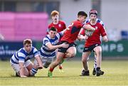 25 January 2024; David Li of CUS evades the tackles of Mikey Kavanagh, centre, and Tommy Byrne of Good Counsel, New Ross, during the Bank of Ireland Leinster Rugby Schools Father Godfrey Cup semi-final match between Good Counsel, New Ross and CUS at Energia Park in Dublin. Photo by Ben McShane/Sportsfile