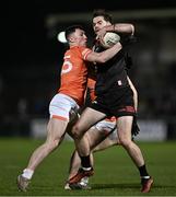 27 January 2024; Dermot Campbell of Louth is tackled by Oisín Conaty of Armagh during the Allianz Football League Division 2 match between Armagh and Louth at BOX-IT Athletic Grounds in Armagh. Photo by Ben McShane/Sportsfile