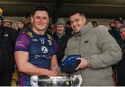 28 January 2024; Wexford captain Lee Chin, left, is presented with the Player of the Match award by Jack McGowan of Phoenix Labs after the Dioralyte Walsh Cup Final match between Wexford and Galway at Netwatch Cullen Park in Carlow.