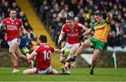 28 January 2024; Eoghan McSweeney of Cork blocks a shot at goal by Peadar Mogan of Donegal during the Allianz Football League Division 2 match between Donegal and Cork at MacCumhaill Park in Ballybofey, Donegal. Photo by Ramsey Cardy/Sportsfile