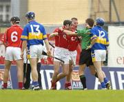 10 July 2004; Referee Barry Kelly has to restrain Cork's John Gardiner and Diarmuid O'Sullivan from Tipperary's Benny Dunne. Guinness Senior Hurling Championship Qualifier, Round 3, Cork v Tipperary, Fitzgerald Stadium, Killarney, Co. Kerry. Picture credit; Brendan Moran / SPORTSFILE
