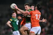 3 February 2024; Ronan Jones of Meath is tackled by Conor O'Neill, behind, and Stefan Campbell of Armagh during the Allianz Football League Division 2 match between Armagh and Meath at BOX-IT Athletic Grounds in Armagh. Photo by Ben McShane/Sportsfile