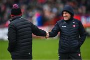 4 February 2024; Derry manager Mickey Harte, right, shakes hands with Tyrone joint-manager Brian Dooher before the Allianz Football League Division 1 match between Derry and Tyrone at Celtic Park in Derry. Photo by Ramsey Cardy/Sportsfile