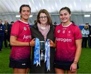 11 February 2024; University of Galway joint captains Fiona Ryan, left, and Tiffanie Fitzgerald are presented with the cup by Camogie Association President, Hilda Breslin, centre, after their side's victory in the Electric Ireland Purcell Cup final match between University of Galway and SETU Carlow at University of Galway Connacht GAA AirDome in Bekan, Mayo. Photo by Sam Barnes/Sportsfile