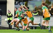 17 February 2024; Ultan Kelm of Fermanagh is charged down by Stephen McMenamin, centre, and Brendan McCole of Donegal during the Allianz Football League Division 2 match between Donegal and Fermanagh at O'Donnell Park in Letterkenny, Donegal. Photo by Ramsey Cardy/Sportsfile