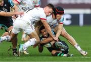 18 February 2024; Keelan Giles of Ospreys is tackled by Mike Lowry, right, and Jude Postlethwaite of Ulster during the United Rugby Championship match between Ospreys and Ulster at Swansea.com Stadium in Swansea, Wales. Photo by Gareth Everett/Sportsfile