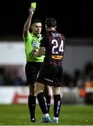 23 February 2024; Referee Rob Hennessy shows a yellow card to Cian Byrne of Bohemians during the SSE Airtricity Men's Premier Division match between St Patrick's Athletic and Bohemians at Richmond Park in Dublin. Photo by Harry Murphy/Sportsfile