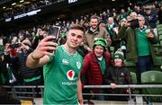 24 February 2024; Jack Crowley of Ireland takes a selfie with supporters after the Guinness Six Nations Rugby Championship match between Ireland and Wales at Aviva Stadium in Dublin. Photo by Ramsey Cardy/Sportsfile