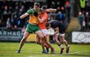 25 February 2024; Armagh goalkeeper Blaine Hughes gathers possession as Hugh McFadden of Donegal and Greg McCabe of Armagh tussle during the Allianz Football League Division 2 match between Armagh and Donegal at BOX-IT Athletic Grounds in Armagh. Photo by Brendan Moran/Sportsfile