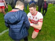 25 February 2024; Ciarán McFaul of Derry signs an autograph for a supporter after the Allianz Football League Division 1 match between Galway and Derry at Pearse Stadium in Galway. Photo by Ray Ryan/Sportsfile