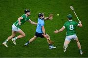 24 February 2024; Sean Currie of Dublin passes the sliotar over the head of William O'Donoghue of Limerick as he is tackled by Conor Boylan of Limerick, left, during the Allianz Hurling League Division 1 Group B match between Dublin and Limerick at Croke Park in Dublin. Photo by Ray McManus/Sportsfile