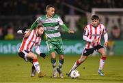 4 March 2024; Graham Burke of Shamrock Rovers in action against Paul McMullan, left, and Adam O'Reilly of Derry City during the SSE Airtricity Men's Premier Division match between Shamrock Rovers and Derry City at Tallaght Stadium in Dublin. Photo by Stephen McCarthy/Sportsfile